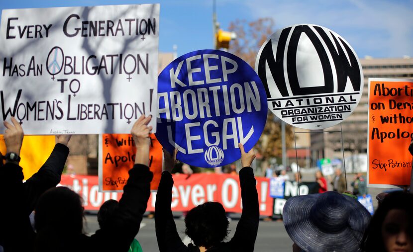 A pro-abortion supporters, foreground,  try to disrupt anti-abortion supporters as they...