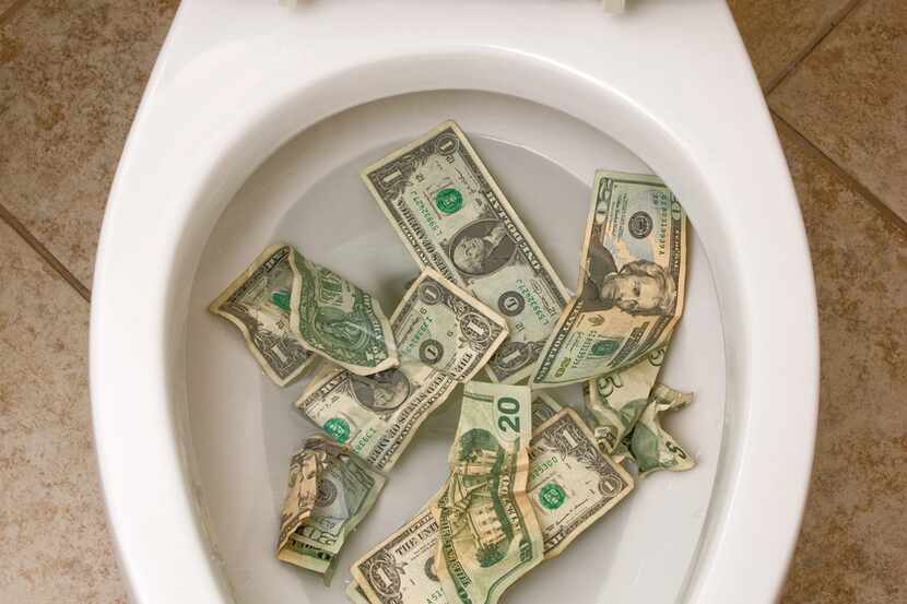 A pile of money getting ready to be flushed down the toilet.