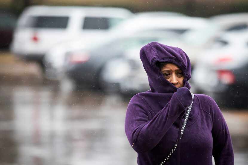 Shoppers bundle against a cold rain in the Wheatland Towne Crossing parking lot on Dec. 22.