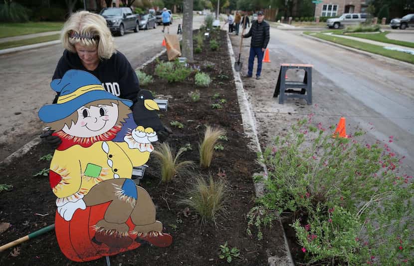 
HOA member Cindy Mauch plants a holiday decoration at the entrance of the Estates of Forest...