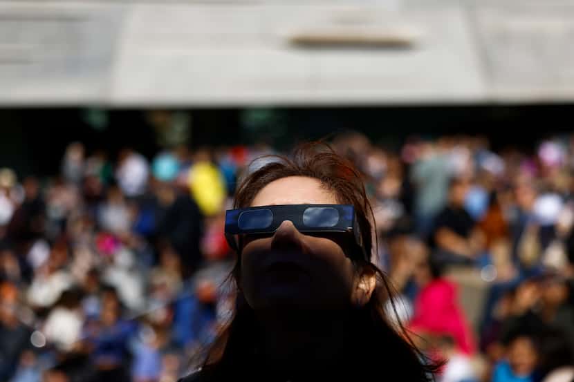 Midia Camacho ve el eclipse solar anular el sábado 14 de octubre de 2023, en el Perot Museum...