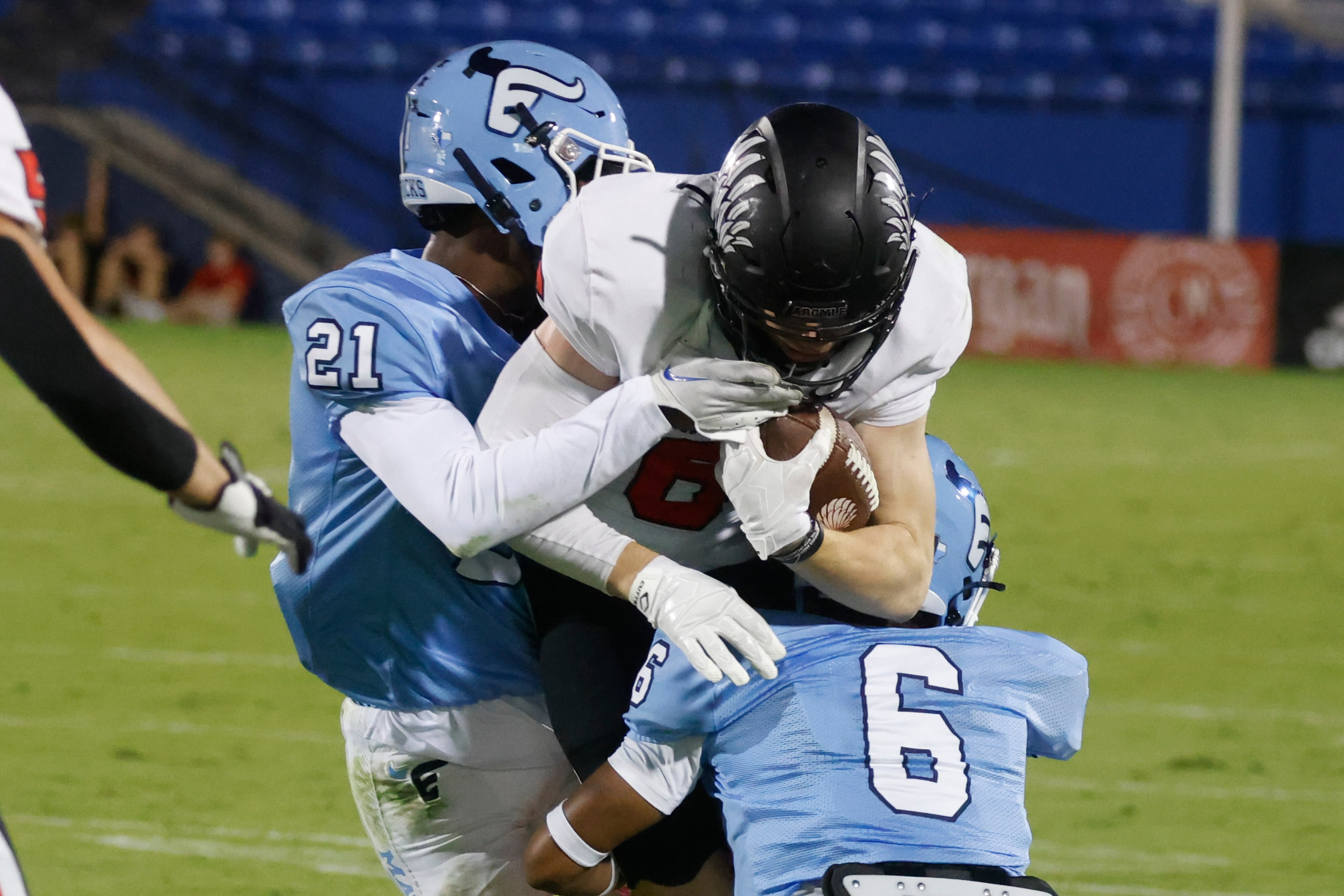 Argyle high school’s Lane Stewart (6), gets tackled by Emerson high school’s Malachi...