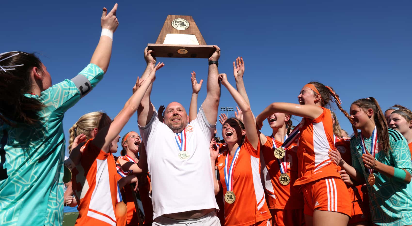  Celina head coach Alexander Adams proudly hoists the Class 4A state championship trophy as...