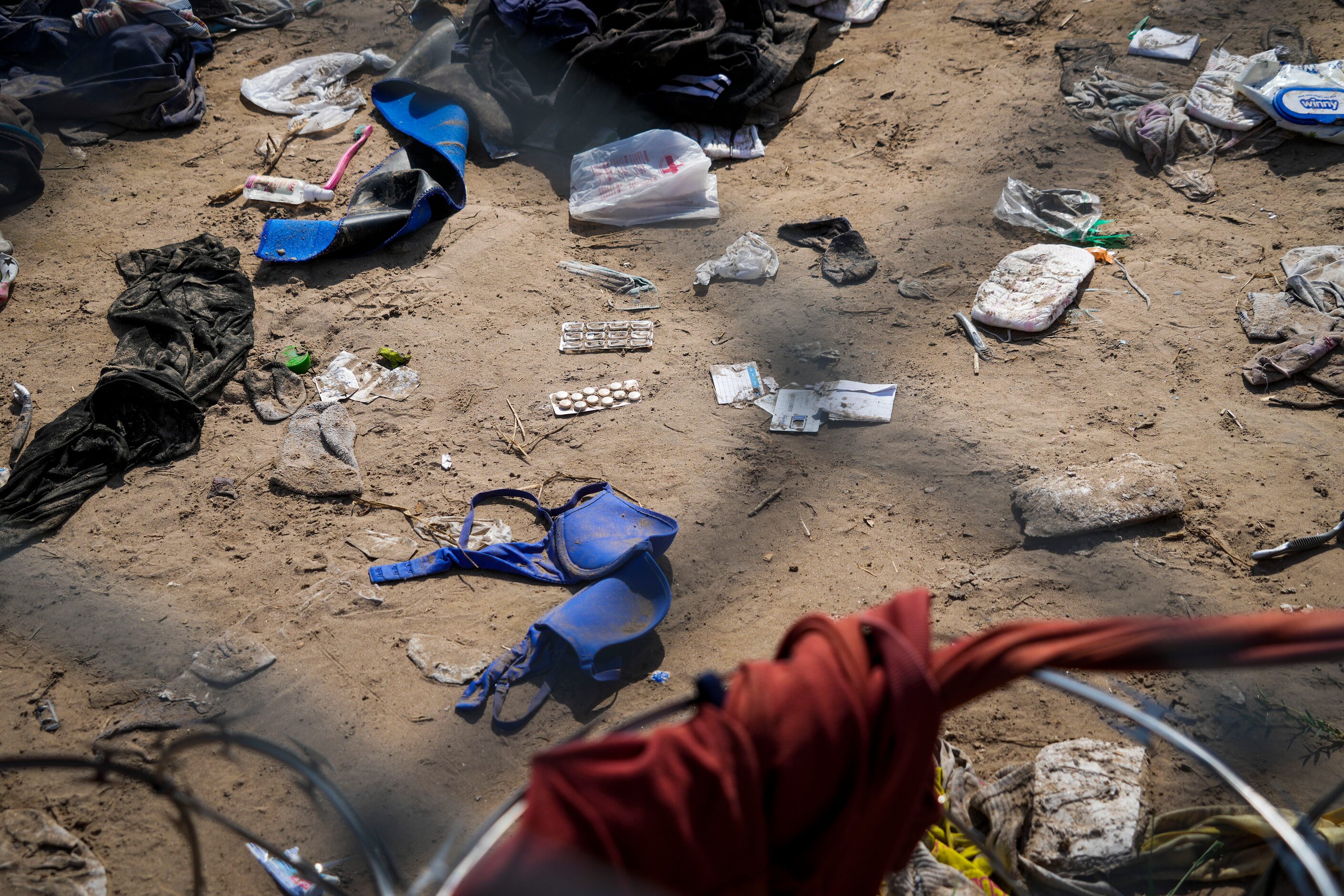 Abandoned clothing and other items strewn between the banks of the Rio Grande on the US side...