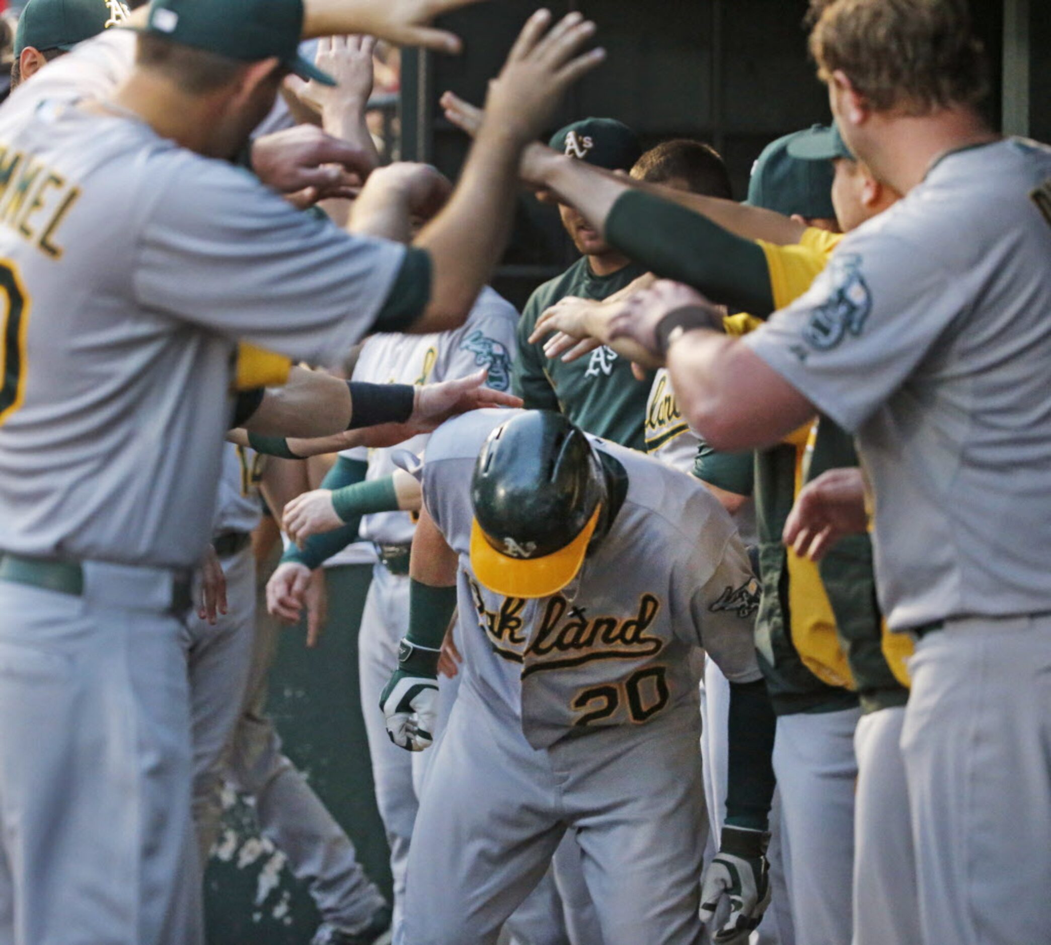 Oakland's Josh Donaldson is greeted by teammates in the dugout after his solo homer in the...