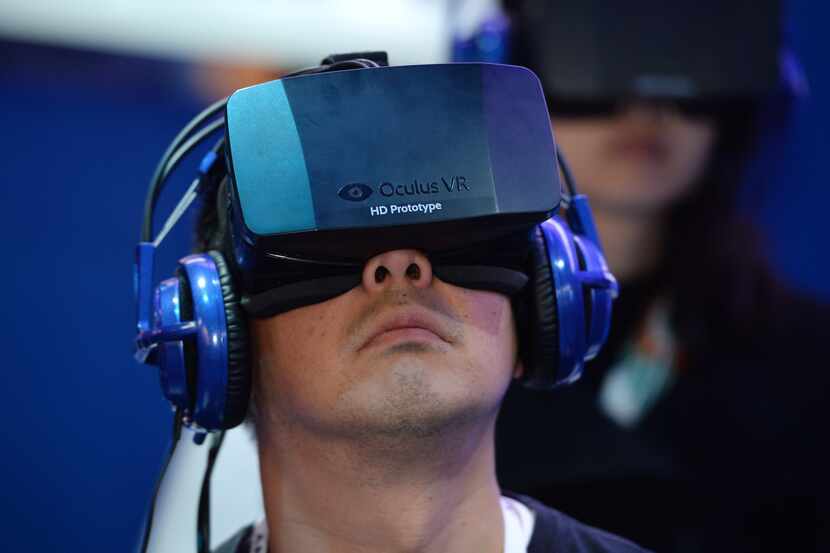 An attendee wears an Oculus Rift virtual reality head-mounted display at the 2014...