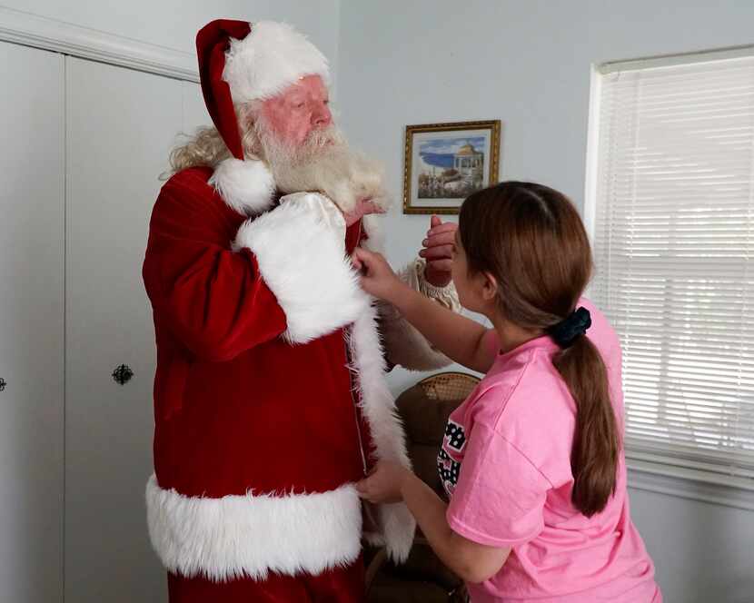 Eva Gomez, 14, helps Allen Cole with his Santa suit. Visual impairment and hearing loss...