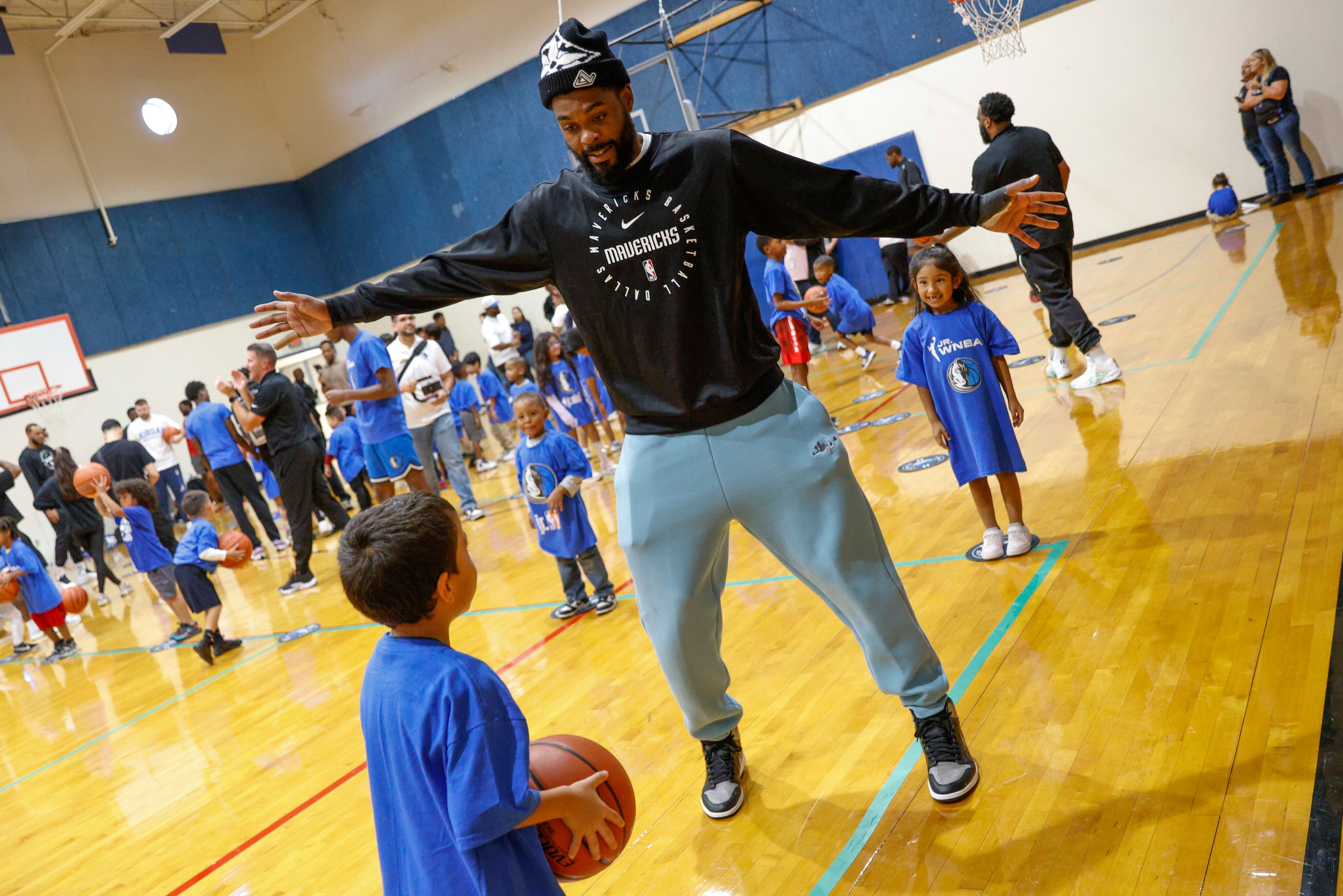 Dallas Mavericks forward Naji Marshall plays with children as they do a passing drill during...