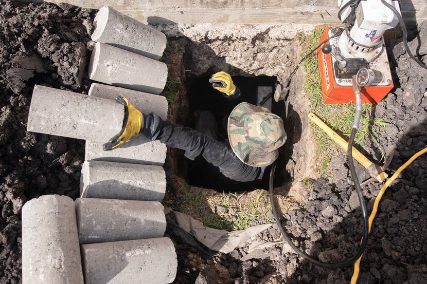 Ishmael Rangel, an employee with HD Foundations, reaches for another concrete piling that he...