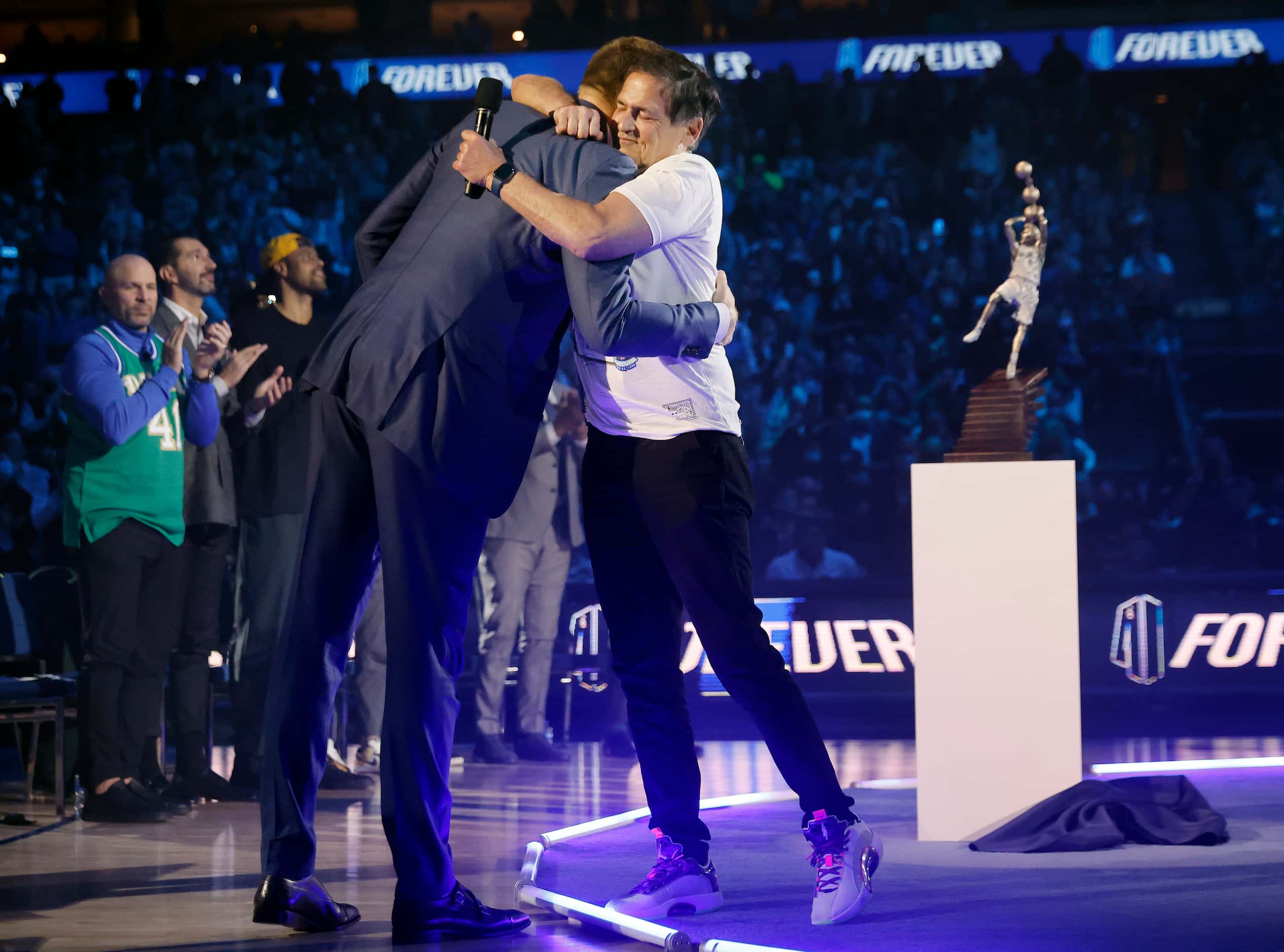 After making some remarks, former Dallas Mavericks All-Star Dirk Nowitzki (left) gives a hug...
