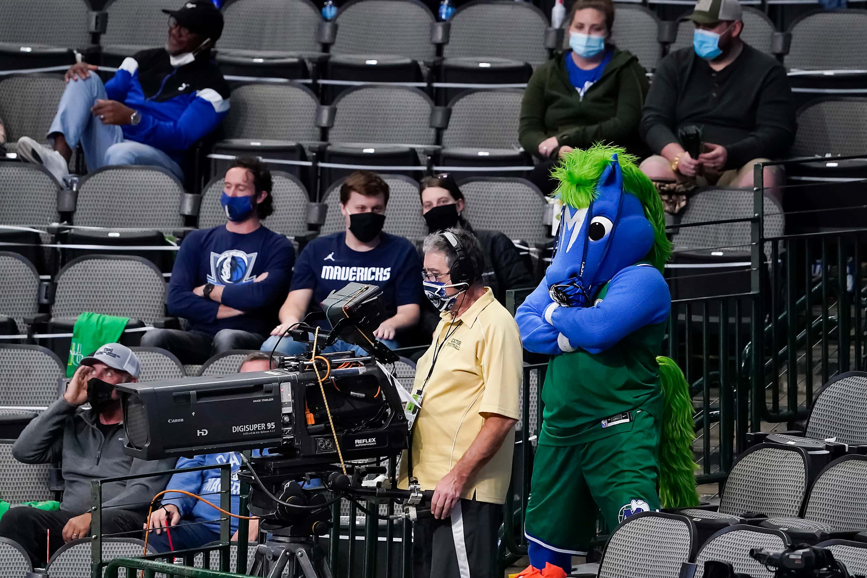 Dallas Mavericks mascot Champ sneaks up behind a broadcast camera operator during the second...