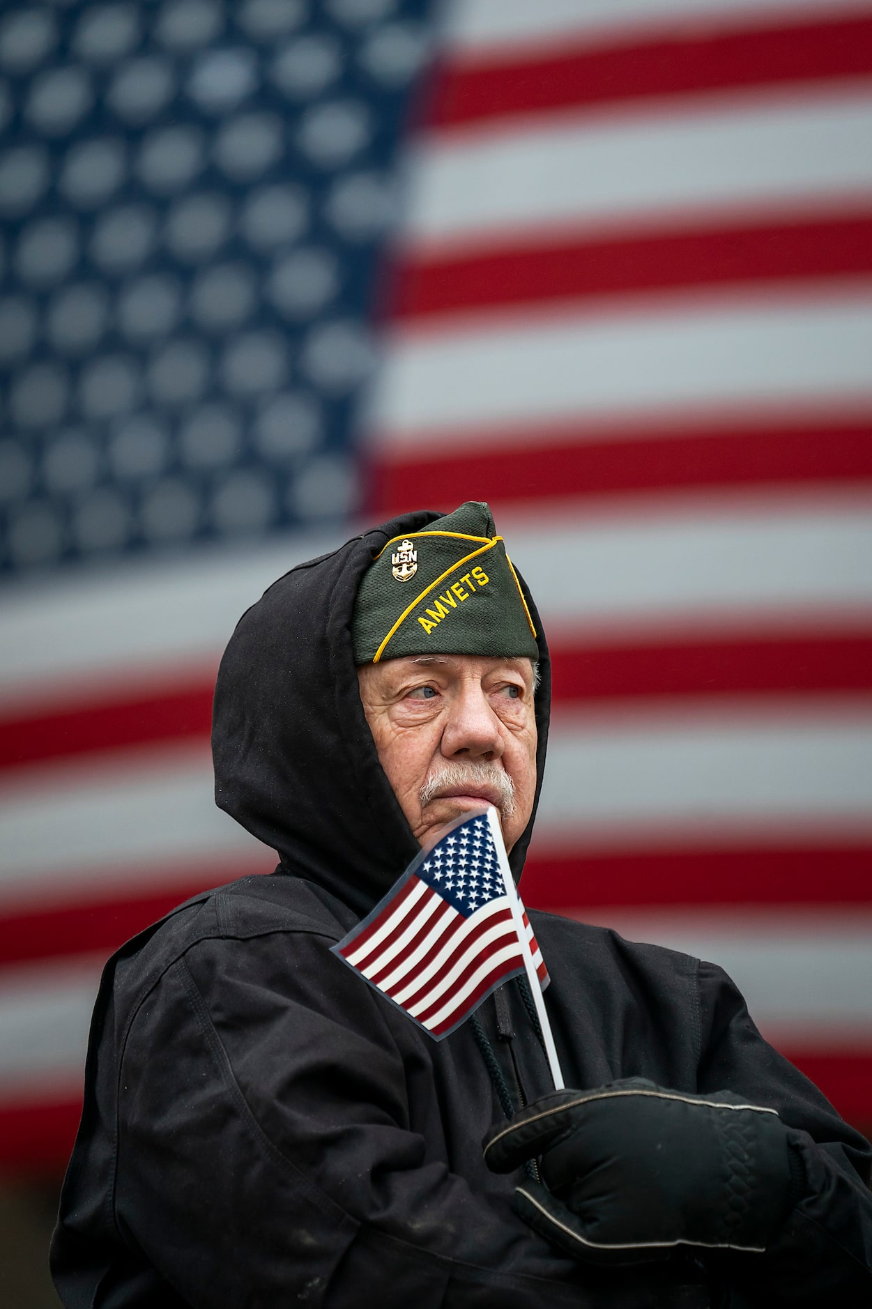 Bobby L. George, a 22-year Navy veteran, bundles up against a cold drizzle as he watches The...