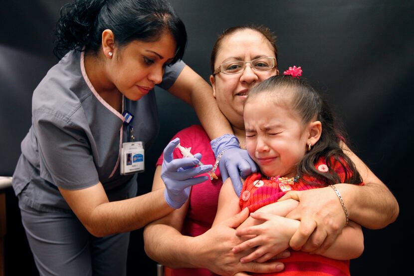 Maria Sanchez, center background, from Dallas, holds her daughter Kamila Rodriguez as Kamila...
