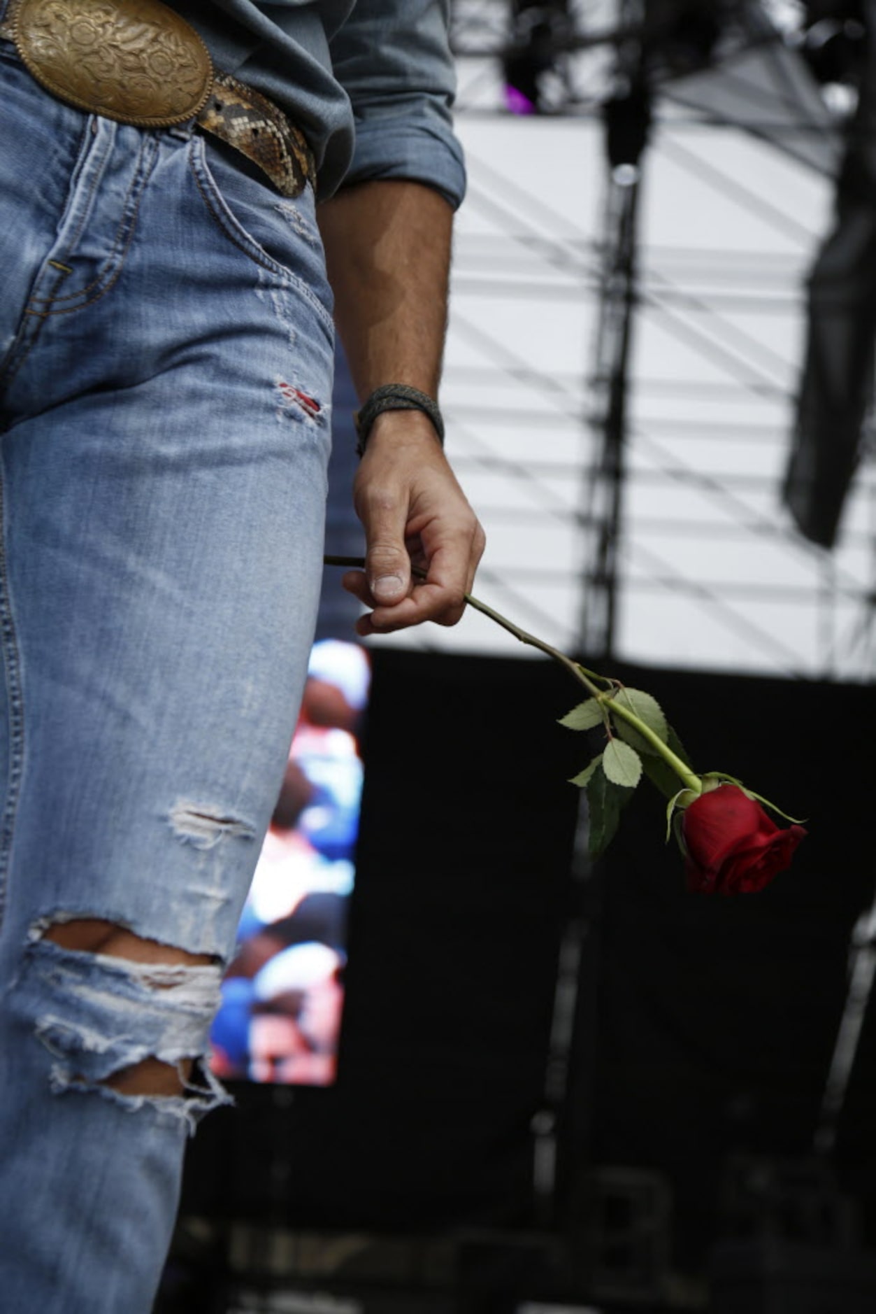 Tim McGraw holds a rose that was given to him by a fan in the crowd during his performance...