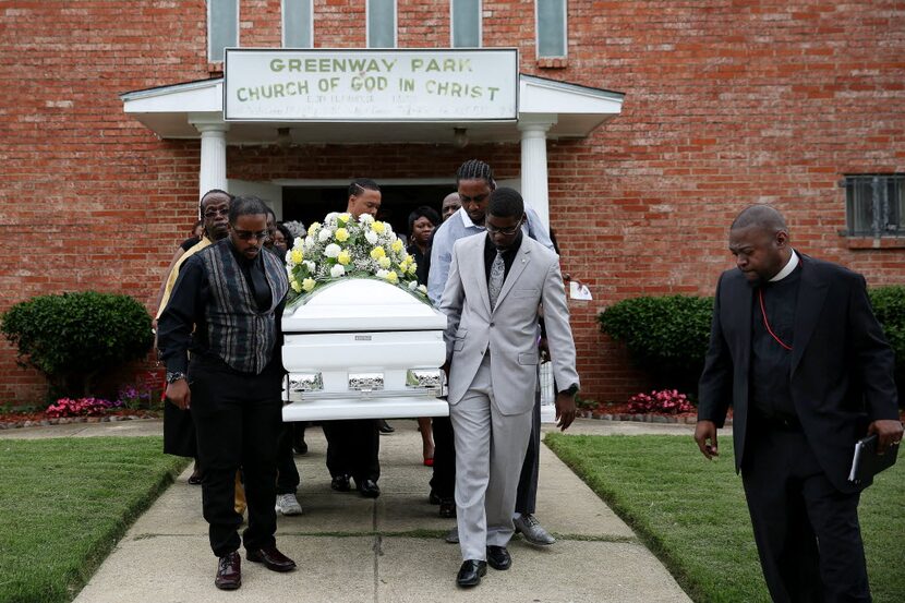  Pastor Fabian Finney (right) accompanied pallbearers carrying the coffin of Debra Williams...