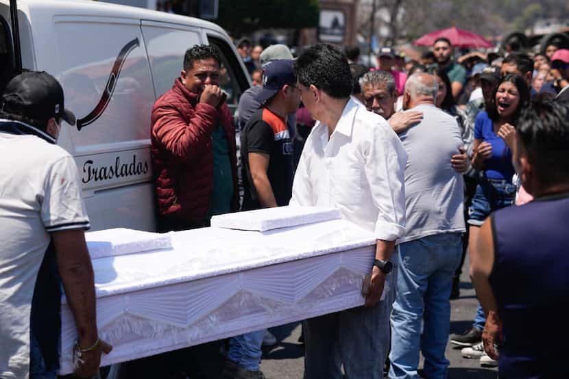 Trabajadores de la funeraria cargan el ataúd con los restos de de una niña de 8 años, en...
