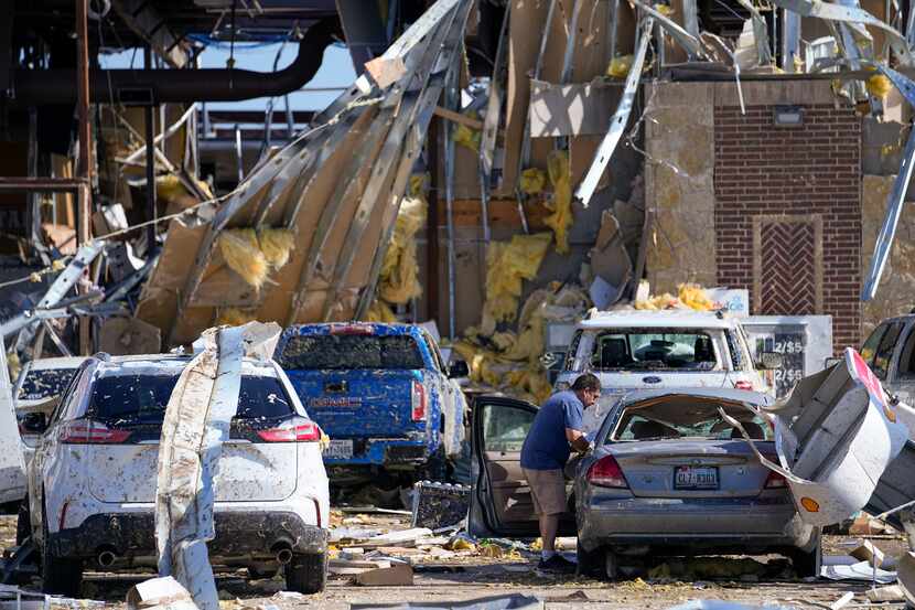 Hugo Parra of Farmers Branch collected belongings from his vehicle after he rode out a...