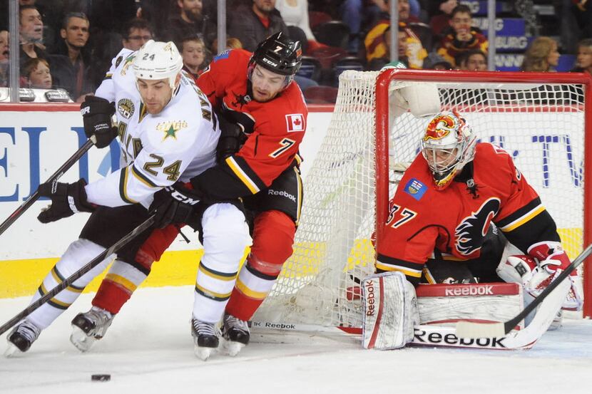 CALGARY, CANADA - FEBRUARY 13: Leland Irving #37 of the Calgary Flames eyes the puck as his...