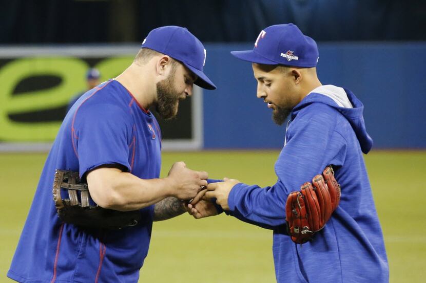 Texas Rangers Mike Napoli (25) helps teammate Rougned Odor (12) with a wardrobe malfunction...