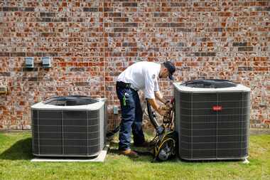 Berkey's Air Conditioning, Plumbing, and Electrical technician Brandon Cronkhite removes the...
