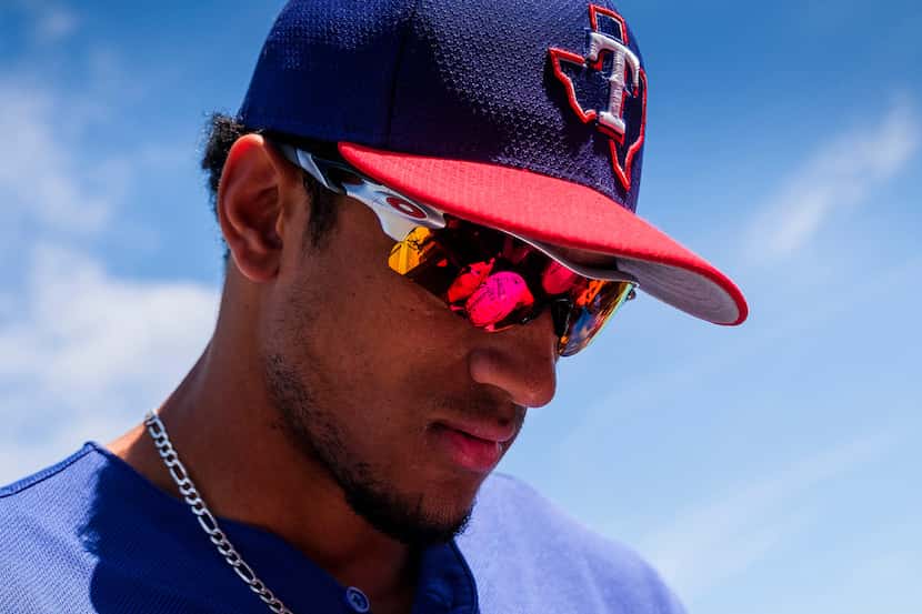 Texas Rangers outfielder Bubba Thompson signs autographs before a spring training baseball...