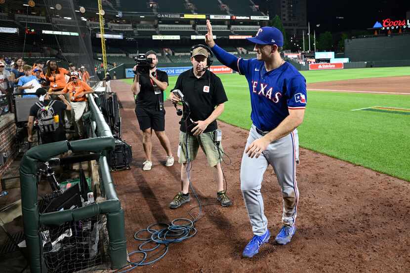 Texas Rangers' Wyatt Langford waves to the stands after a baseball game against the...
