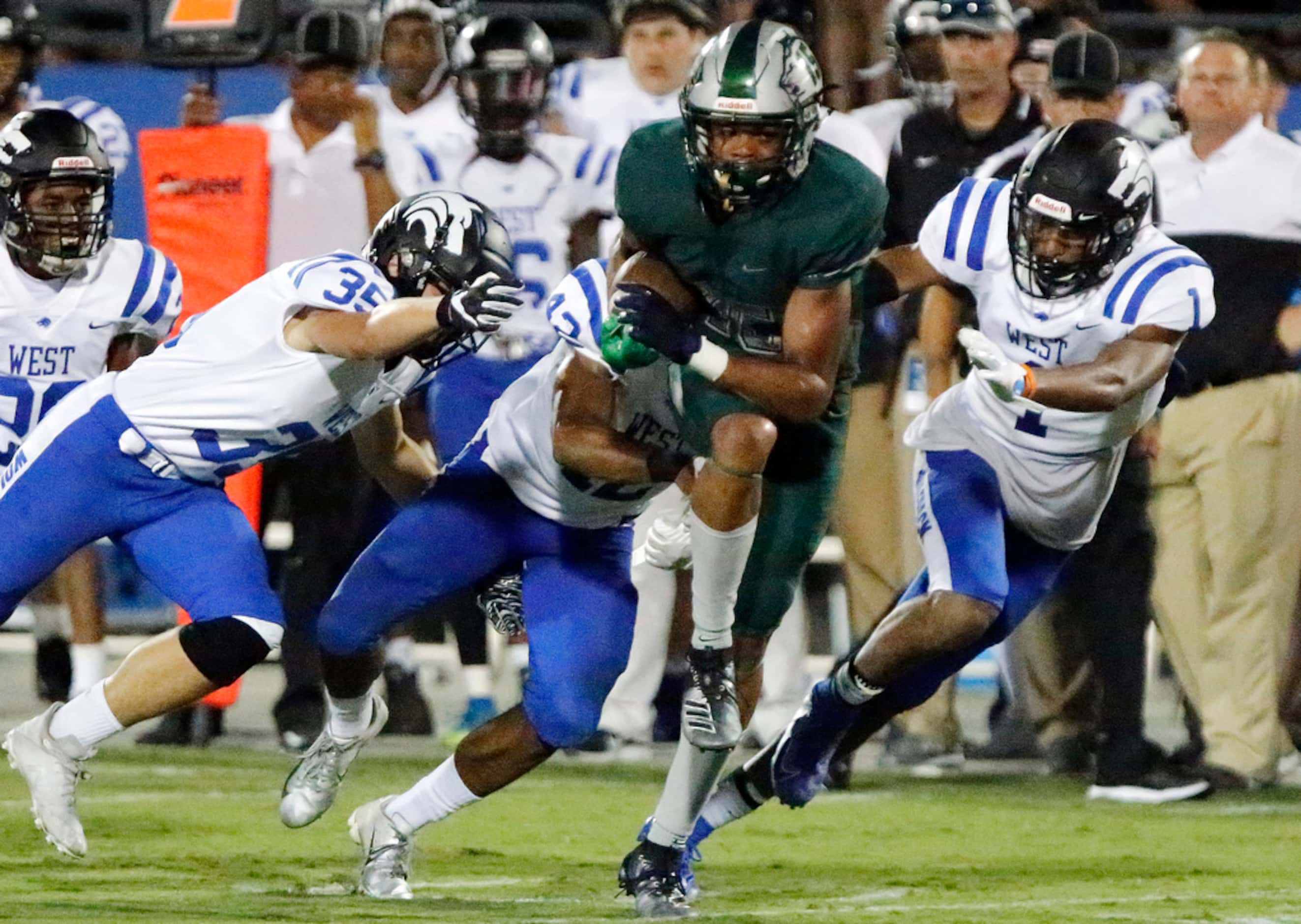 Reedy High School wide receiver Zion Washington (15) breaks free from a host of defenders to...