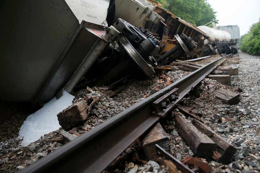 A white substance spilled from one of the cars lying tilted off the tracks Wednesday morning...