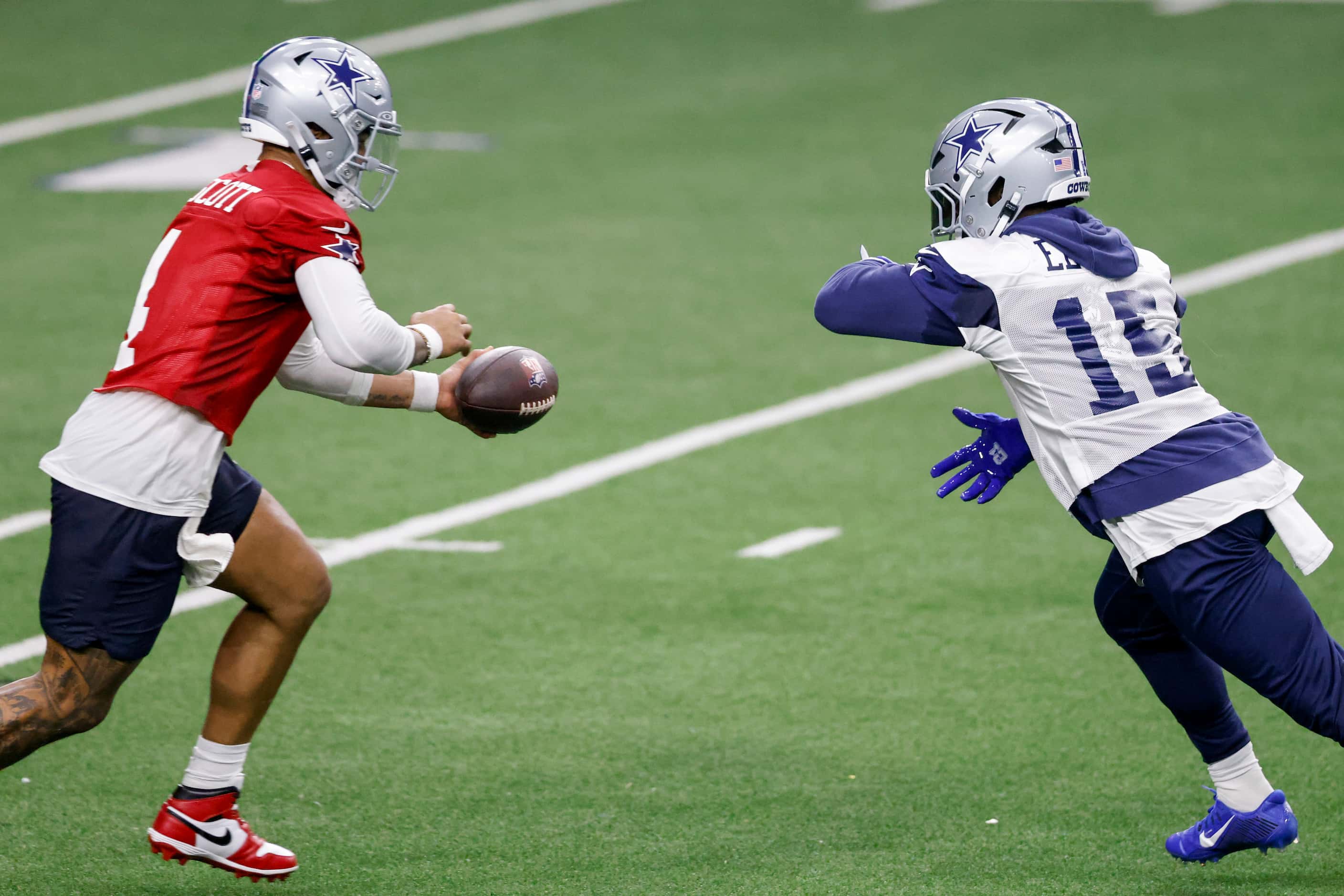Dallas Cowboys quarterback Dak Prescott (4) fakes a handoff to running back Ezekiel Elliott...
