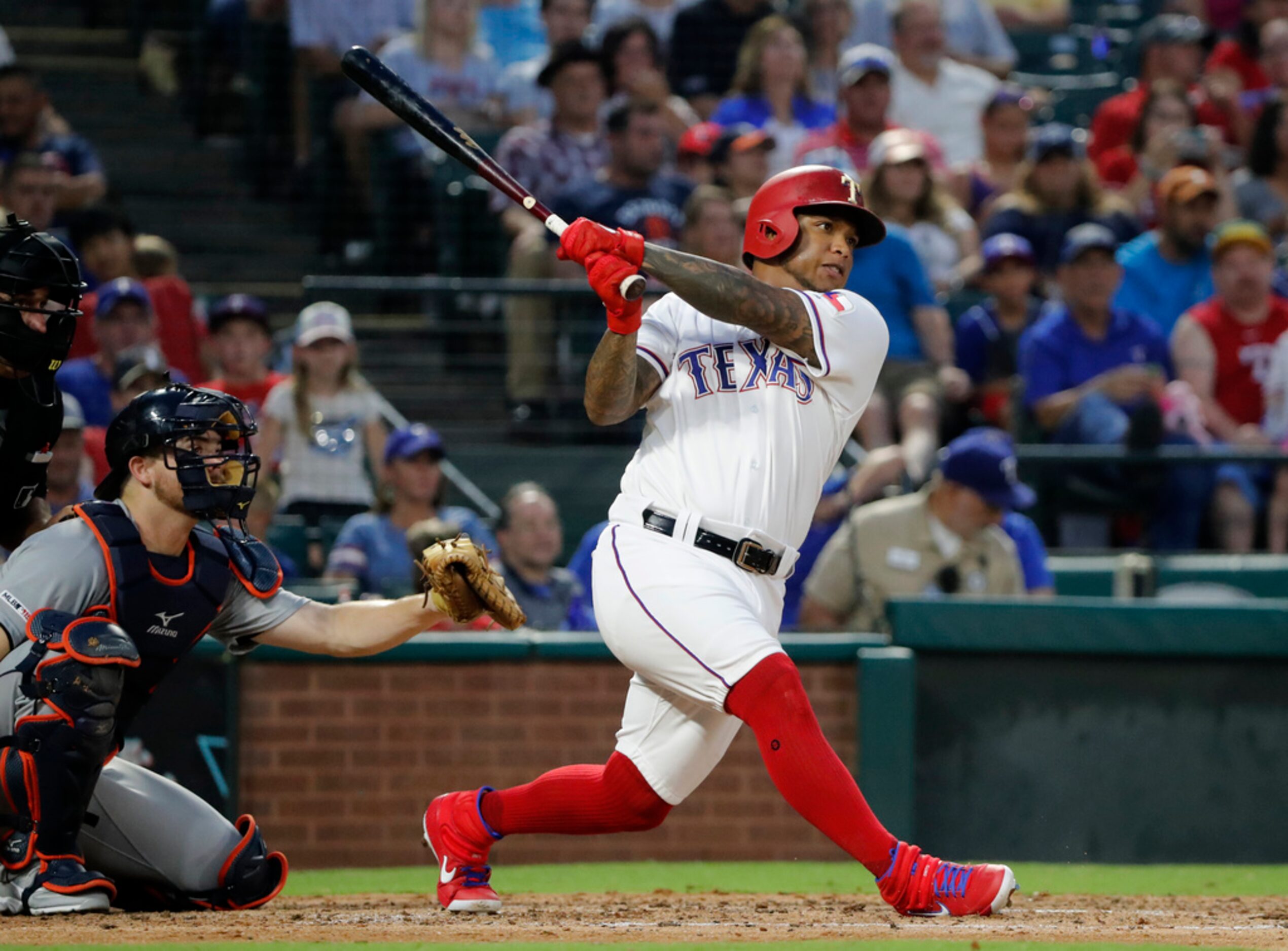 Texas Rangers' Willie Calhoun follows through on a solo home run as Detroit Tigers' Jake...