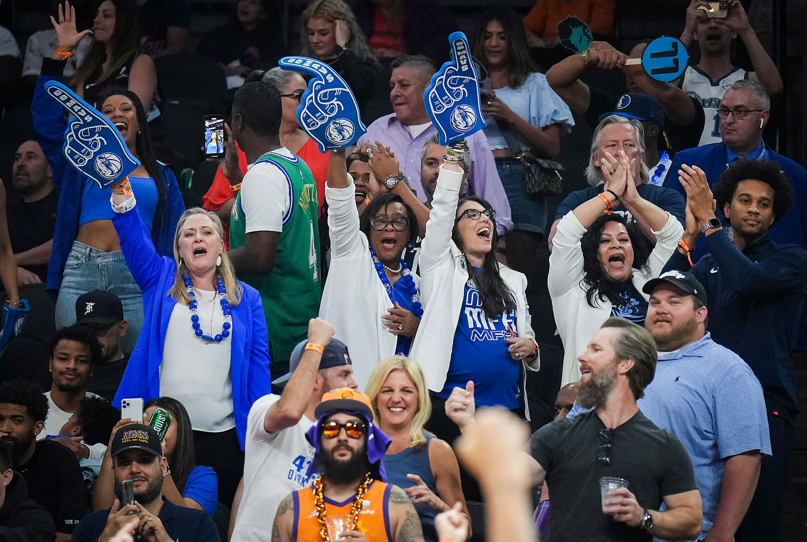 Dallas Mavericks fans, including team CEO Cynt Marshall (center) celebrate during the fourth...