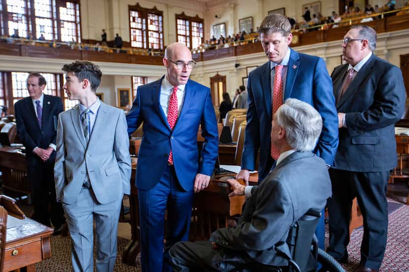 Gov. Greg Abbott (right, back to camera) chats with House Speaker Dennis Bonnen (2nd from...