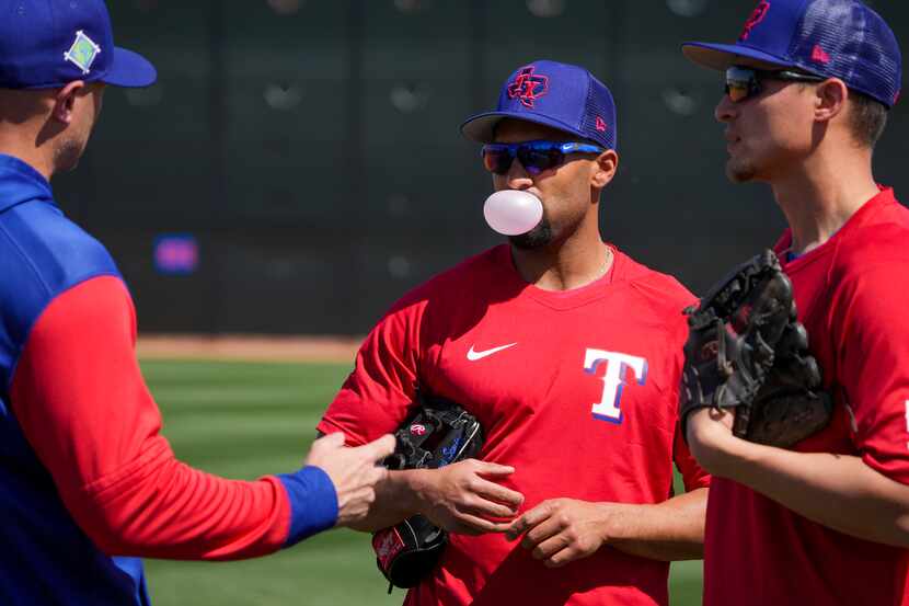 Texas Rangers infielder Marcus Semien blows a bubble as he talks with fellow infielder Corey...