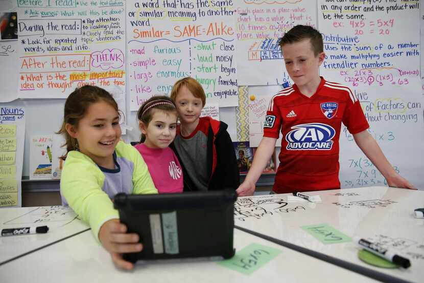 Third-graders take a selfie with a tablet after working on a mathematics equation at White...
