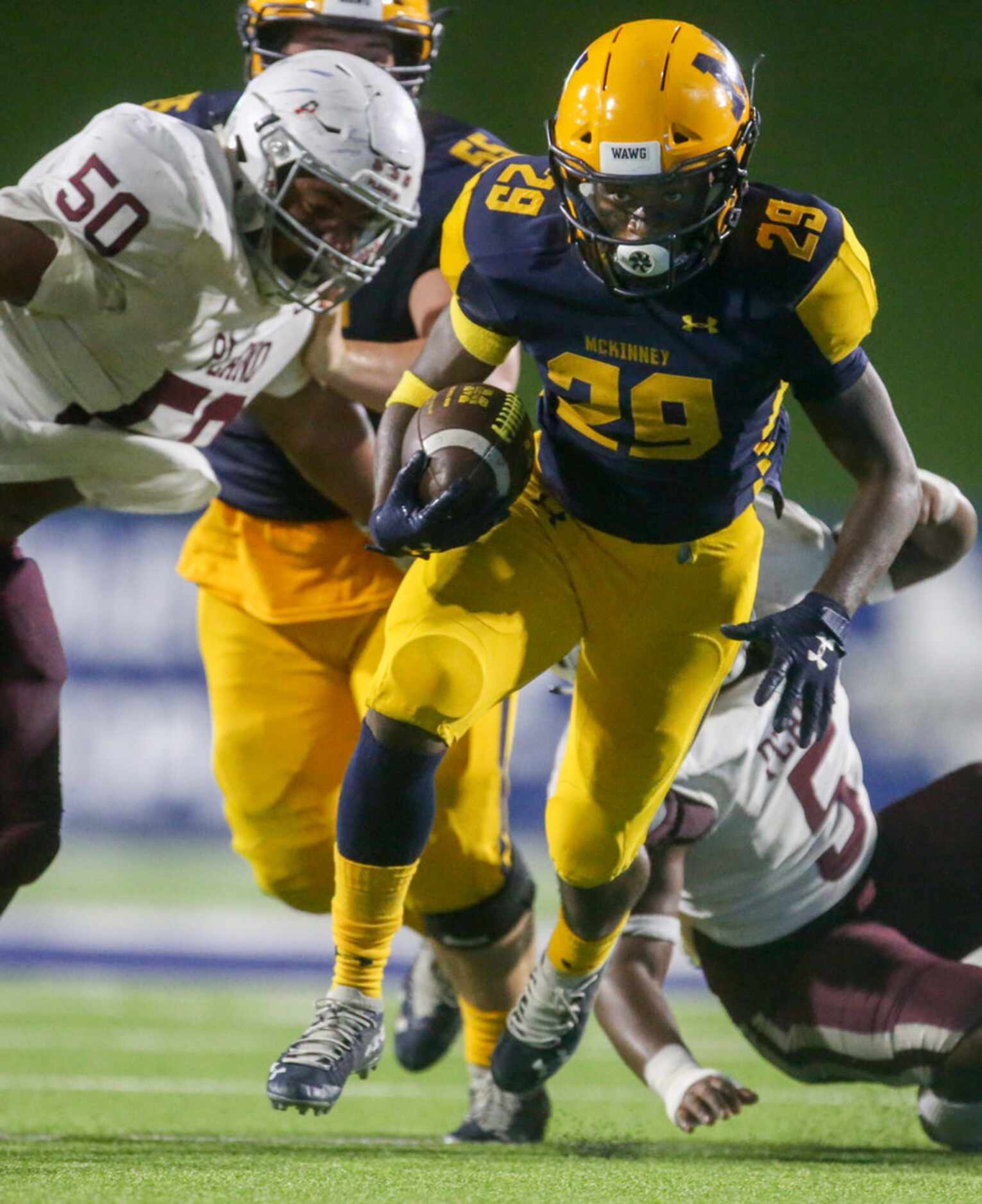 McKinney OJ Reed (29) carries the ball past Plano defensive lineman David Smith (50) and...