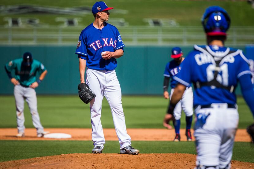 Texas Rangers pitcher Mike Minor waits on the mound for manager Jeff Banister to come take...