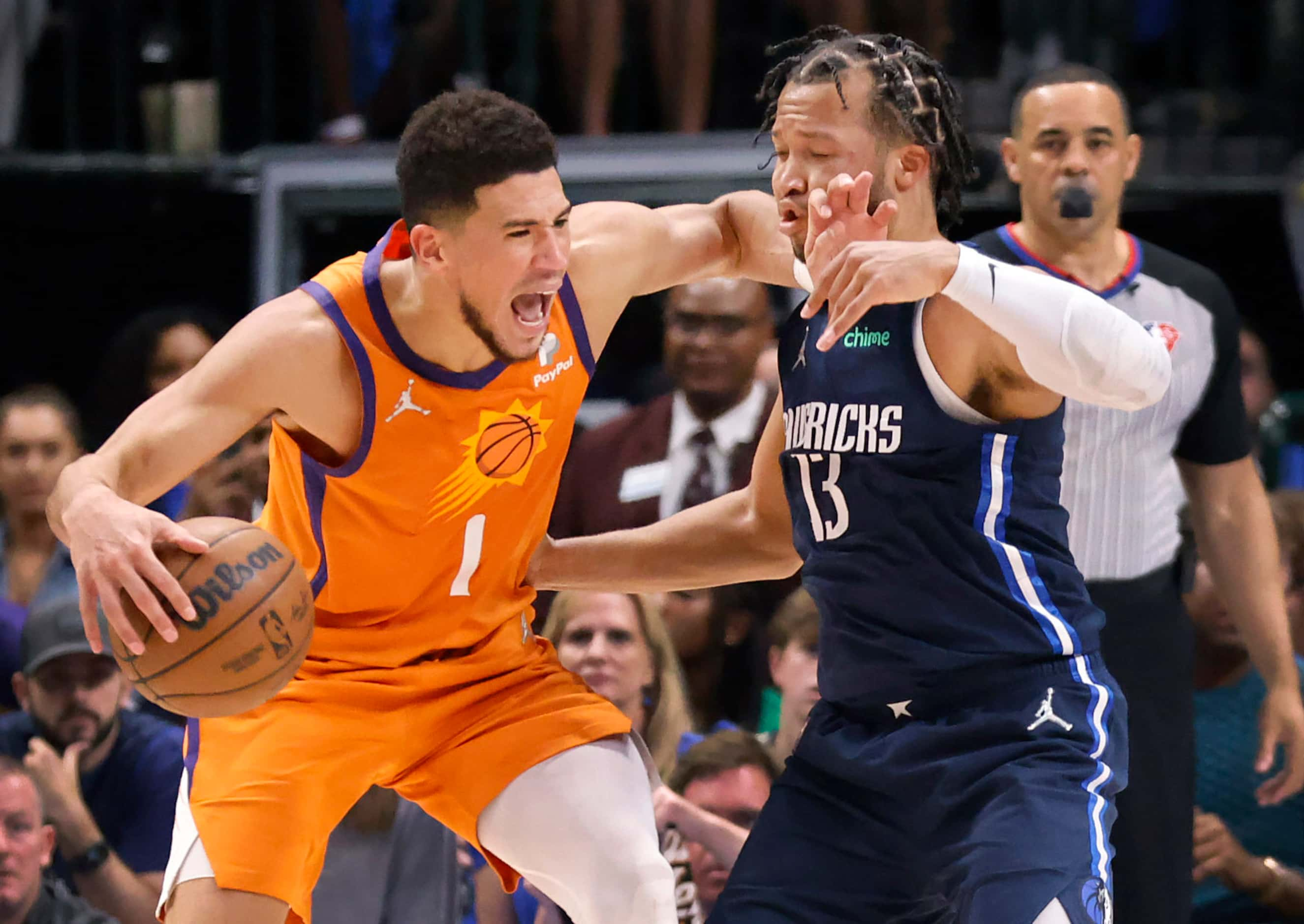 Phoenix Suns guard Devin Booker (1) gives a forearm to the face of Dallas Mavericks guard...