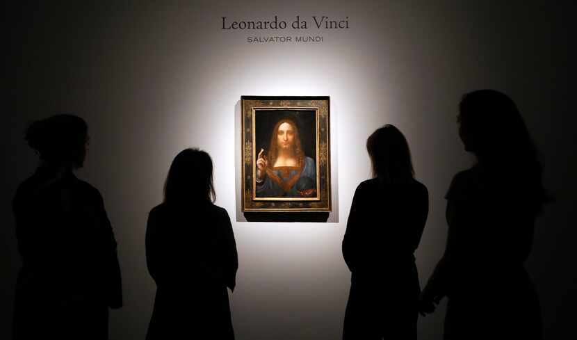 People gathered around Leonardo da Vinci's "Salvator Mundi" at a Christie's auction room in...