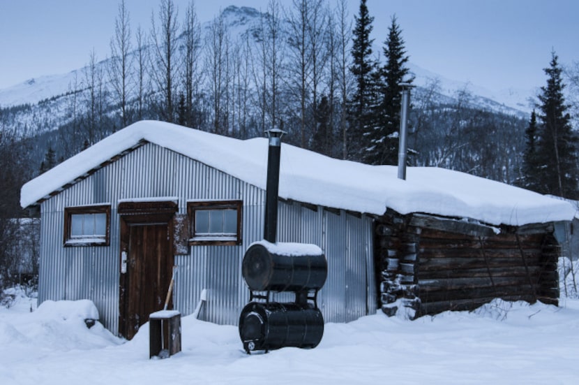 A one-room log cabin serves as Wiseman's aurora viewing site. The corrugated structure in...