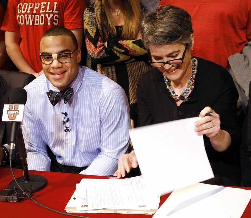Solomon Thomas, left, is all smiles as his mother Chris Thomas signs paper work during the...