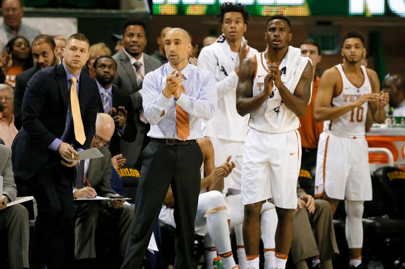 Texas head coach Shaka Smart and the bench cheer on after a basket against Baylor in the...