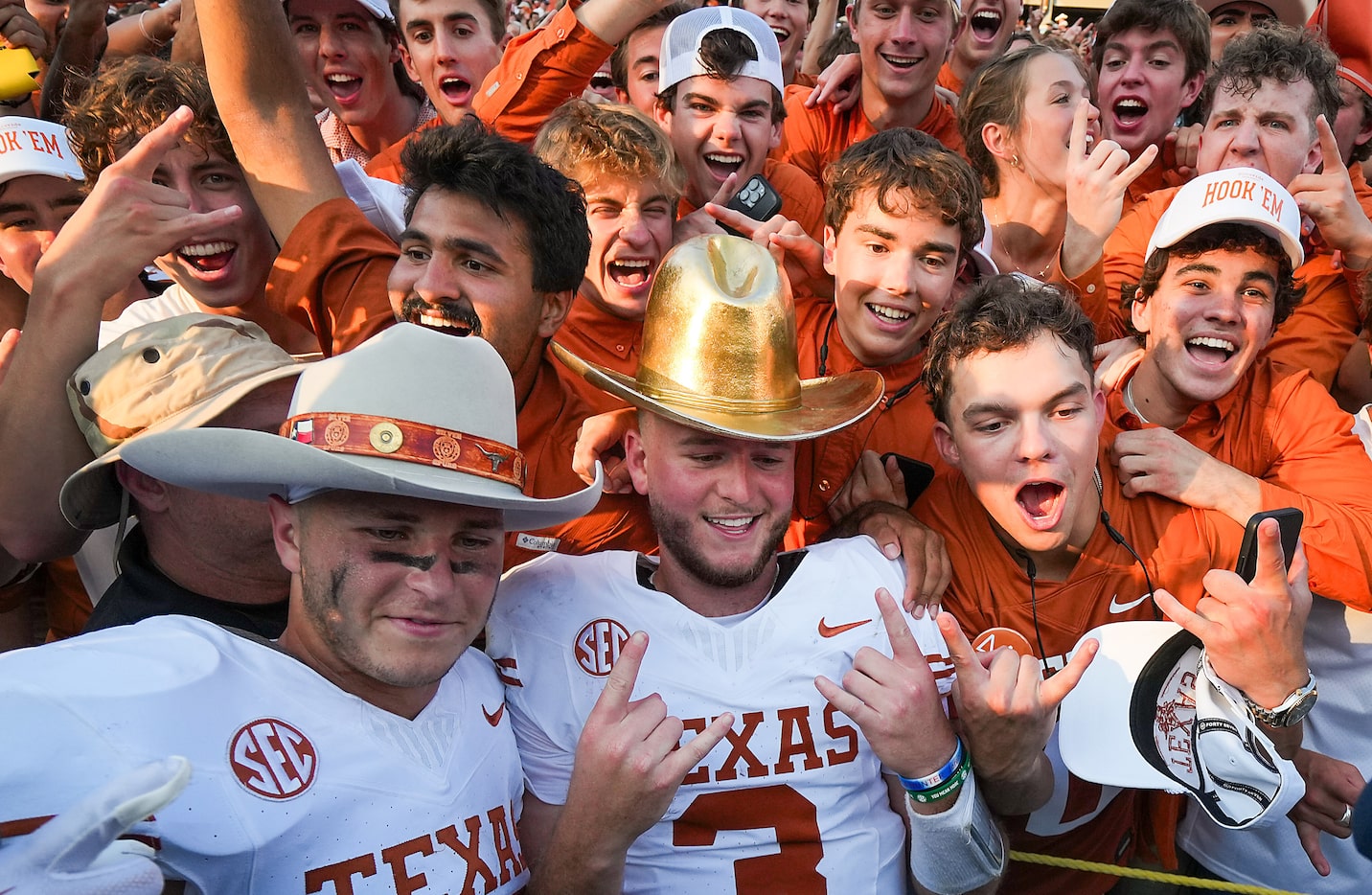 Texas quarterback Quinn Ewers (3) wears the Golden Hat Trophy as he celebrates with...