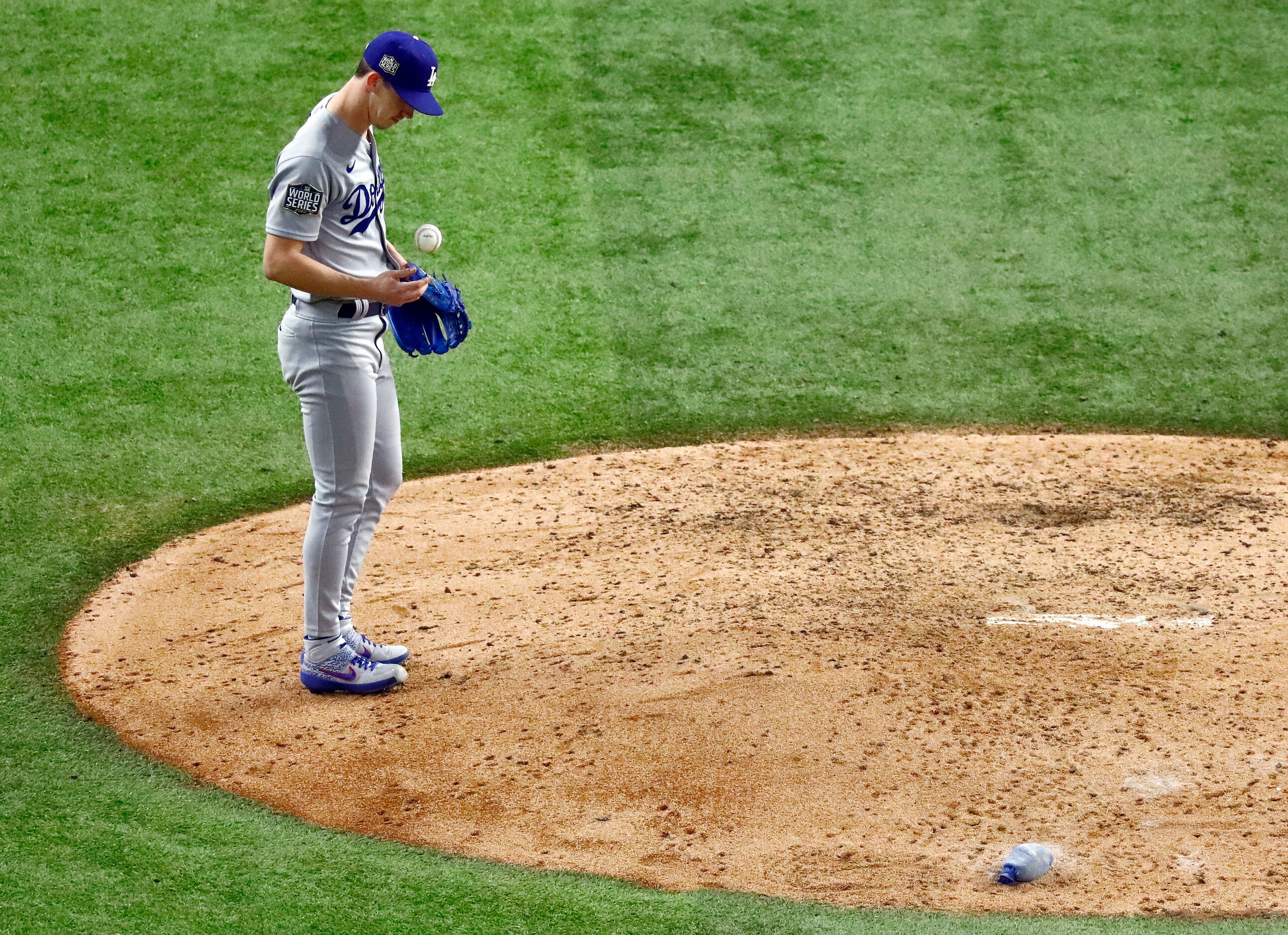 Los Angeles Dodgers starting pitcher Walker Buehler (21) flips the baseball after giving up...