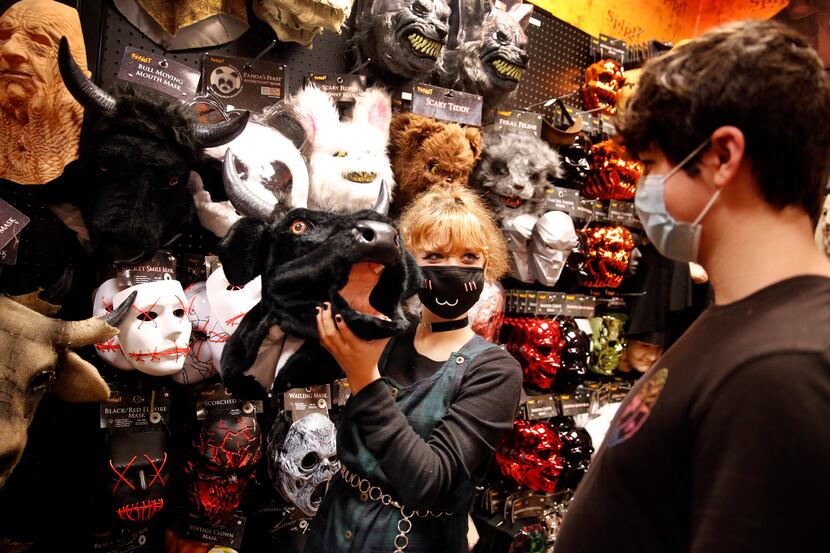 Leah Staten mimics a cow mooing as she and her friend Joel Fernandez look through masks at...