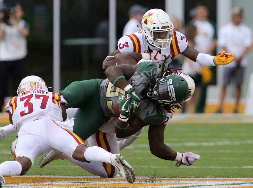 Baylor running back JaMycal Hasty is tackled by Iowa State linebacker Mackenro Alexander,...