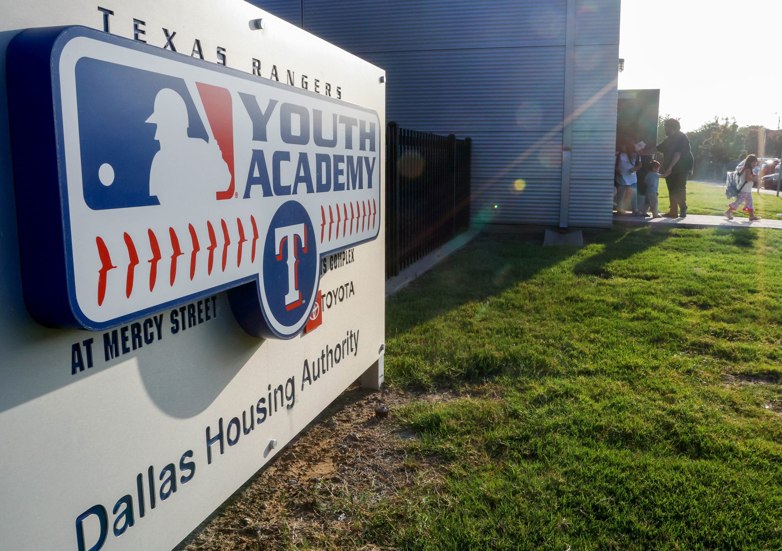 Families exit the Texas Rangers MLB Youth Academy in Dallas after taking part in a...