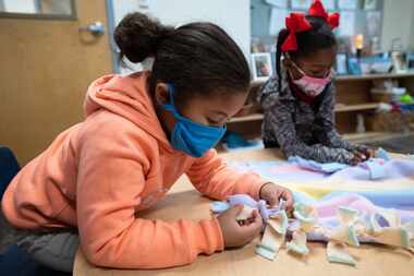 Kinder students Camri Ethridge, 6, left, and Eden Coleman, 6, make hand made tassels to a...