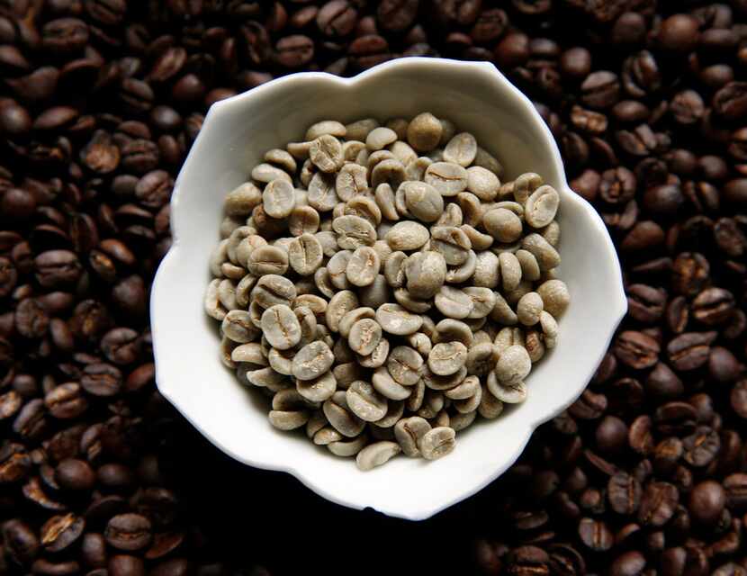 Sweet Maria's Brazil Dry Process Serrinha Yellow Bourbon green coffee beans sit on top of...