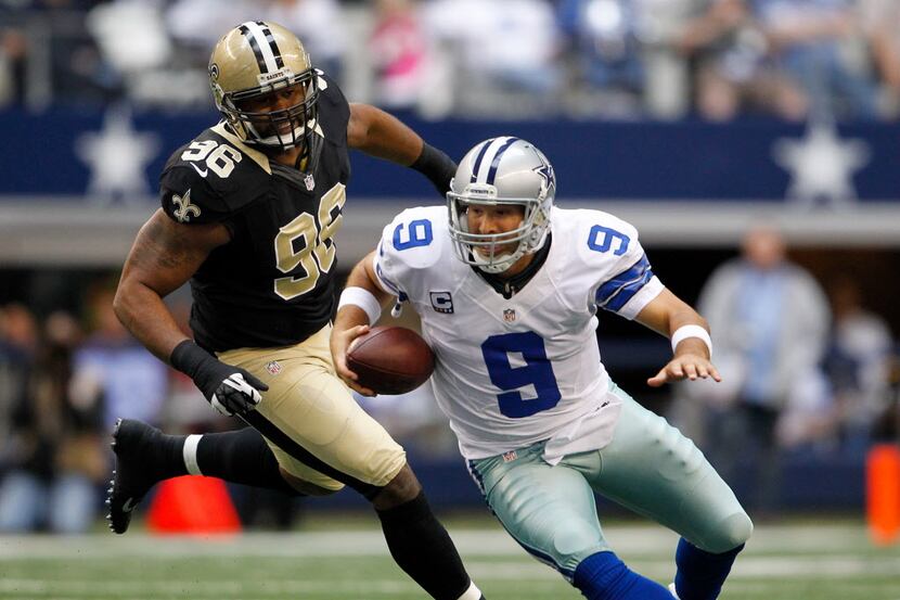 Dallas Cowboys quarterback Tony Romo (9) slips as he escapes New Orleans Saints defensive...