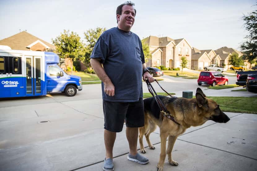  Justin Mann, shown here with his guide dog, Garvey, after a ride home from TAPS Public...
